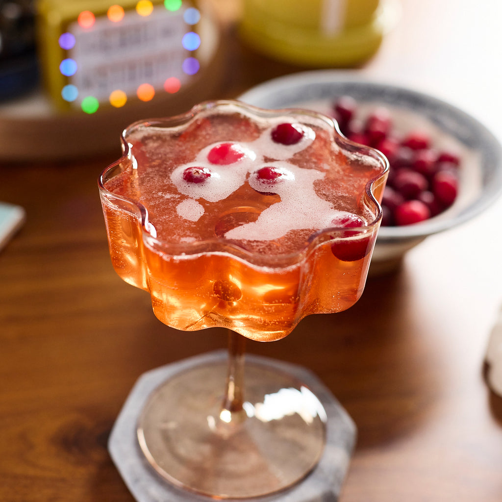 Tea infused cocktail with cranberries floating in it. 