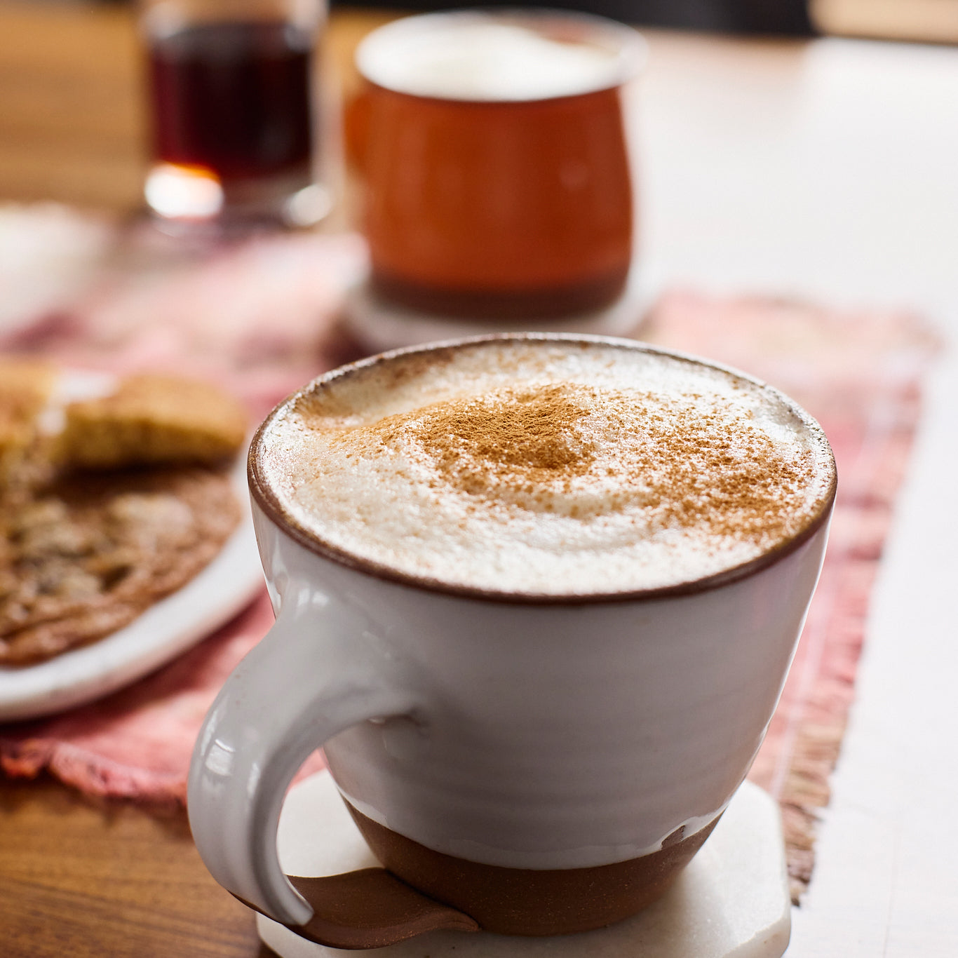 Tea latte in a white mug with cinnamon on top.