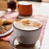 Tea latte in a white mug with cinnamon on top.