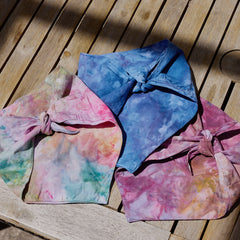 Three ice-dyed pet bandanas tied on picnic table by Goldy Way
