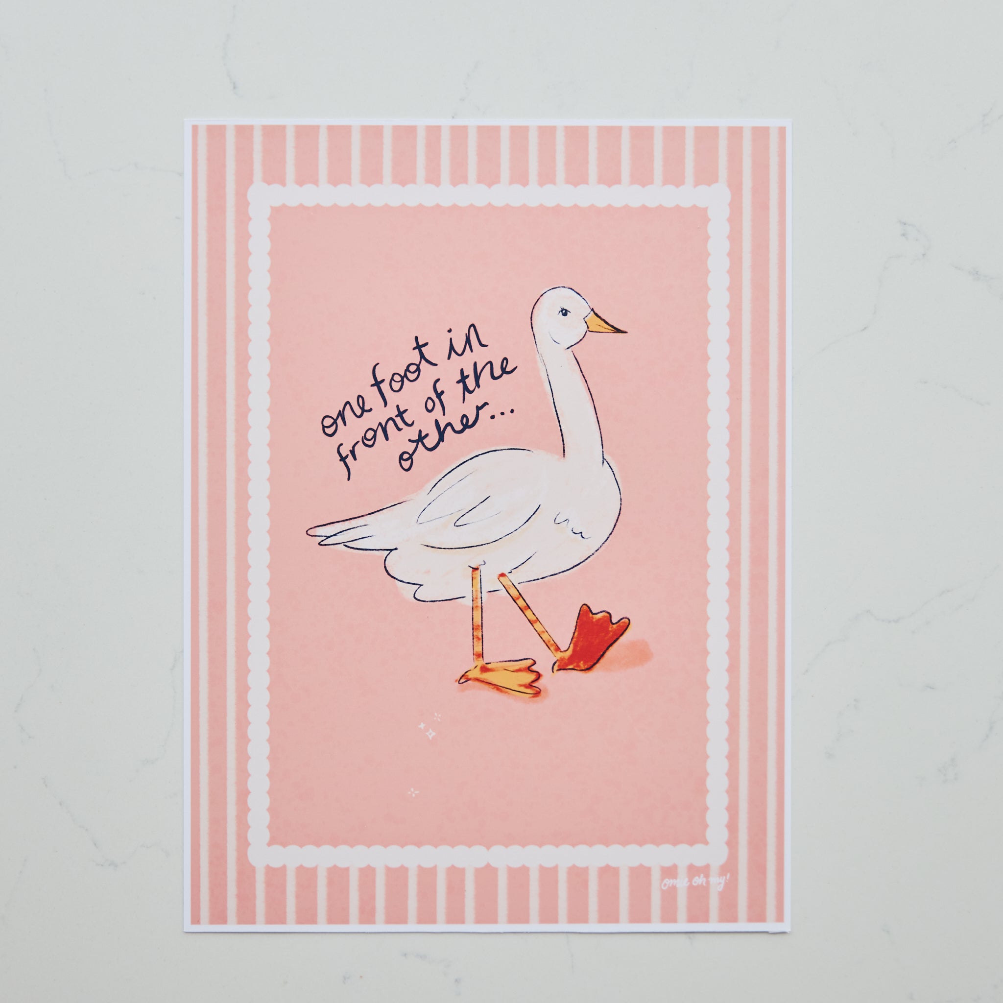 A square art print featuring a white goose with one foot in front of the other, set against a pink background with a striped border. Handwritten text reads 'one foot in front of the other.