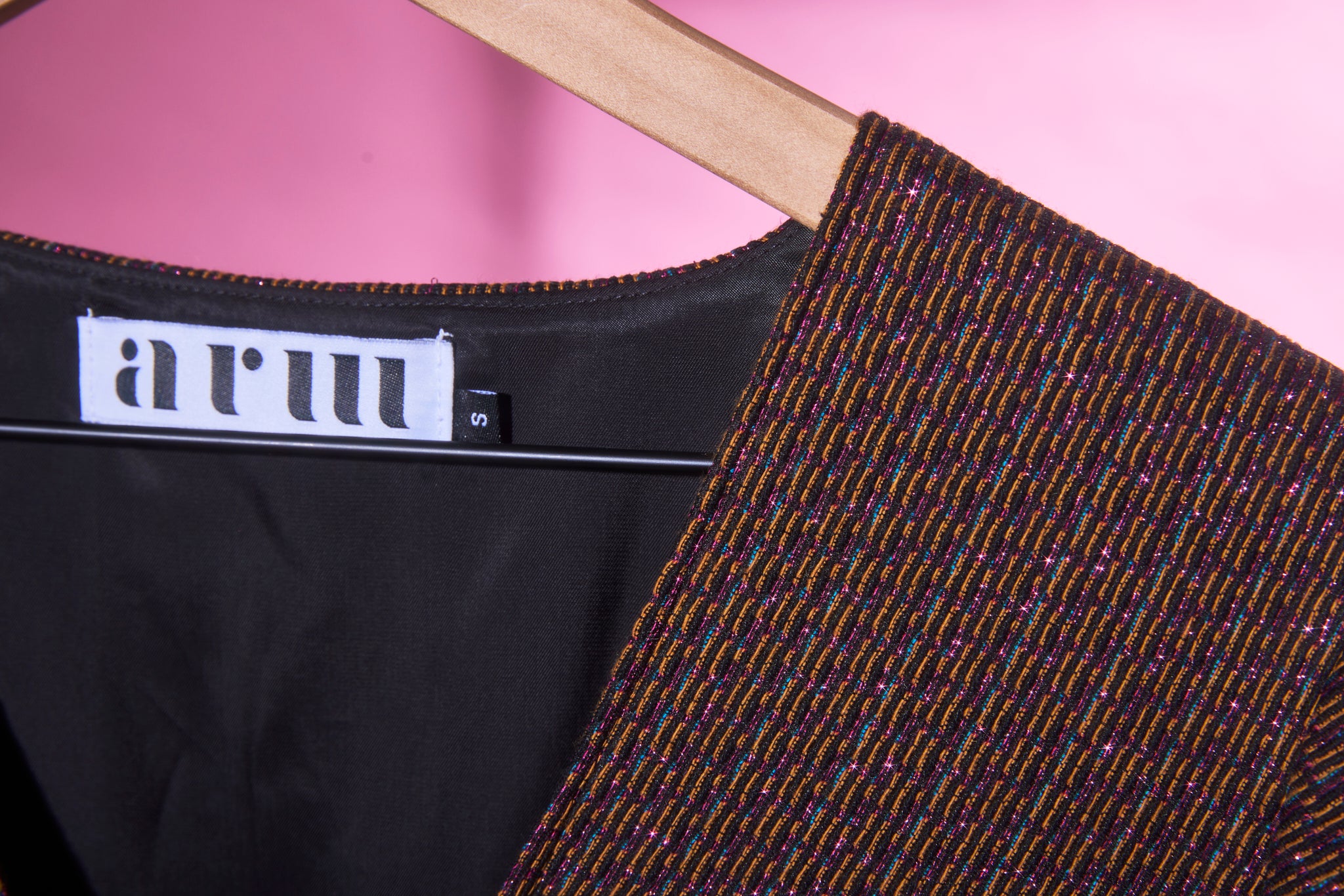a closeup of the metallic jacquard fabric used in ARW's deep V block dress. Light is reflecting off the metallic thread.