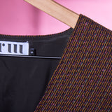 a closeup of the metallic jacquard fabric used in ARW's deep V block dress. Light is reflecting off the metallic thread.