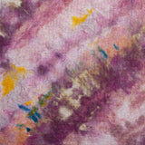 A close-up of a textured fabric with an abstract tie-dye or watercolor pattern in shades of purple, pink, peach, yellow, and blue.