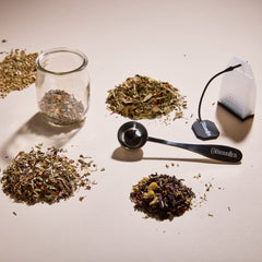 Cup of Communitea's function tea sampler set. Tea blends are accompanied by a small clear glass, spoon and reusable tea sachet.