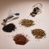 Cup of Communitea's around the world tea sampler set. Tea blends are accompanied by a small clear glass, spoon and reusable tea sachet.