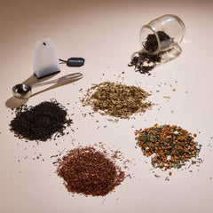 Cup of Communitea's around the world tea sampler set. Tea blends are accompanied by a small clear glass, spoon and reusable tea sachet.