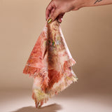 A hand holding a Goldy Way fabric napkin.