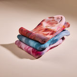 three of Goldy Way's hand-dyed crew socks, each in a different color. From top to bottom, colors shown are Solstice, (orange with reds and purple), Lake Effect (blue with darker blue and pink), and Winterberry (dark fuchsia with blue and orange).