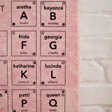 A closeup on Goldy Way's limited-edition alphabet of famous women wall hanging, showing off several letters, including that A is for Aretha Franklin, B is for Beyoncé, F is for Frida Kahlo, G is for Georgia O'Keeffe, K is for Katherine Hepburn, L is for Lucinda Williams, P is for Patti Smith, and Q is for Queen Latifah.