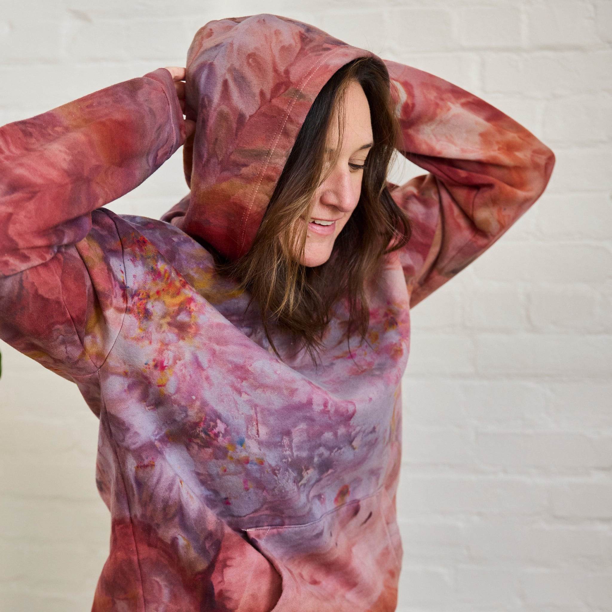 A closeup on Goldy Way's ice-dyed unisex sweatsuit, featuring the Solstice color hoodie as worn on a model.