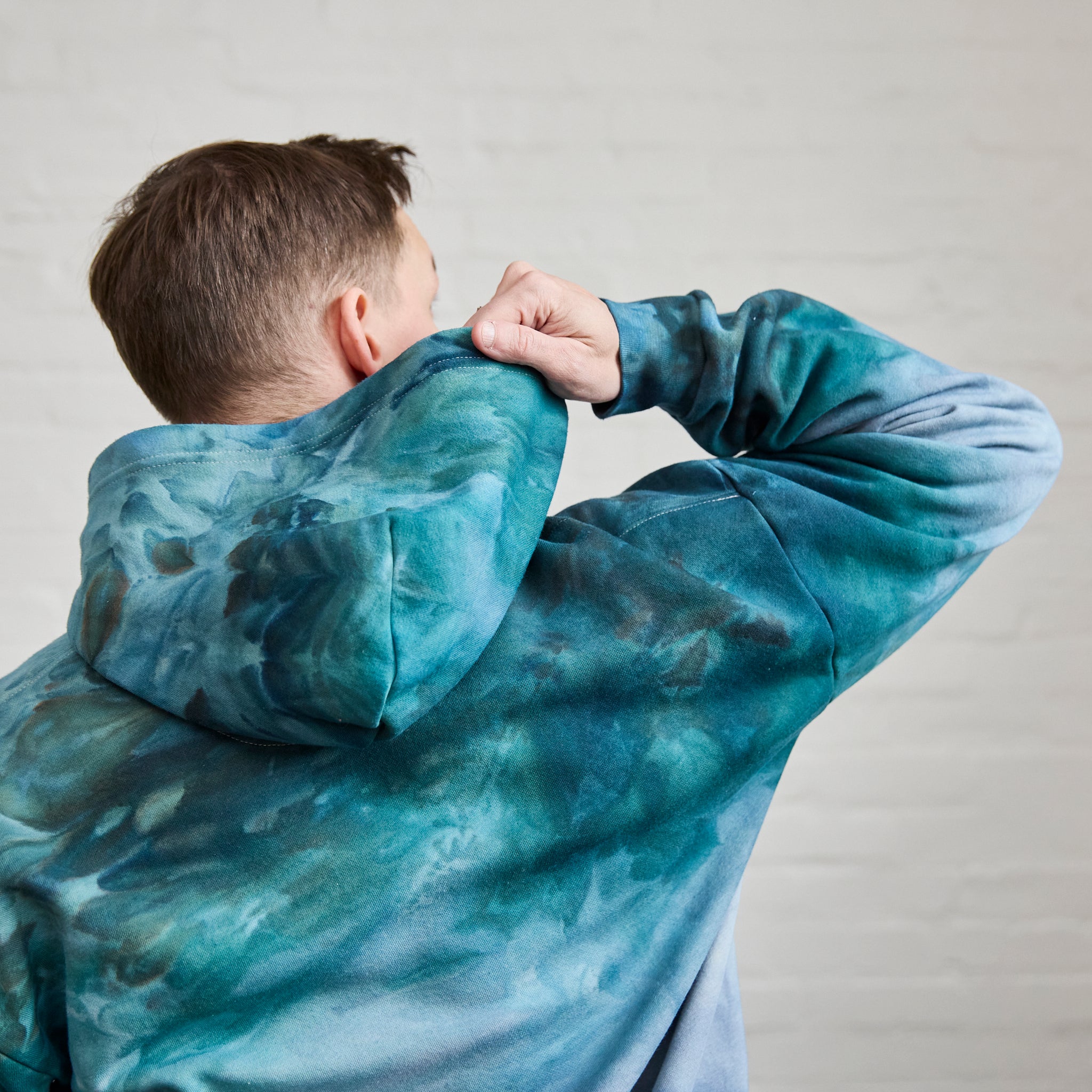 A closeup on the back of Goldy Way's ice-dyed unisex sweatsuit, zoomed in on the back of the Lake Effect version of the hoodie.