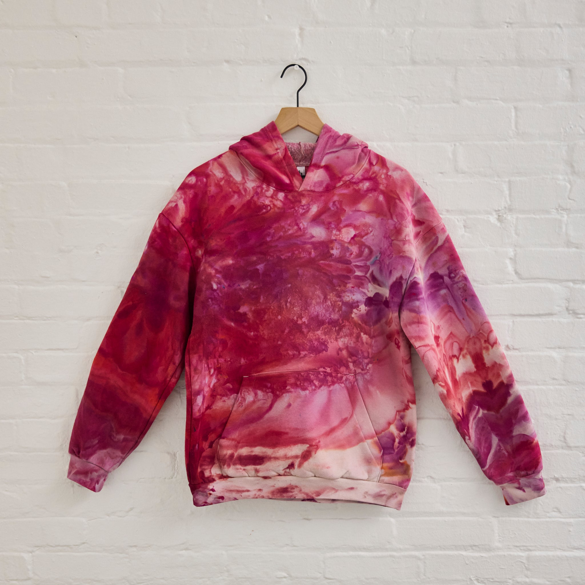 the front of Goldy Way's ice-dyed unisex sweatshirt, with the Winterberry color displayed on a hanger.