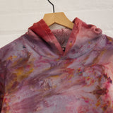 the front of Goldy Way's ice-dyed unisex sweatshirt, with the Solstice color displayed on a hanger.
