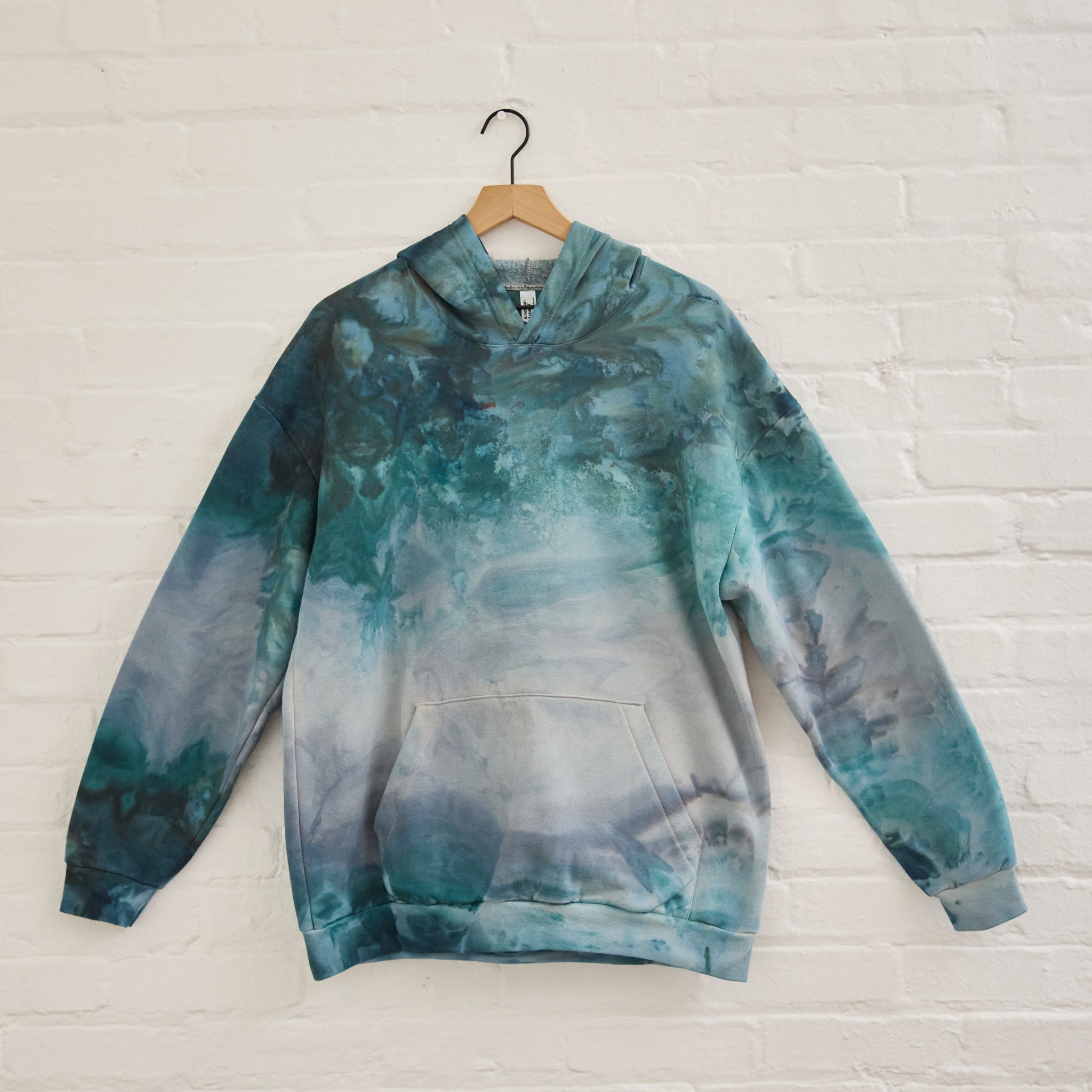 the front of Goldy Way's ice-dyed unisex sweatshirt, with the Lake Effect color displayed on a hanger.