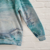 A closeup of Goldy Way's ice-dyed unisex sweatshirt, featuring a sleeve in the Lake Effect color.
