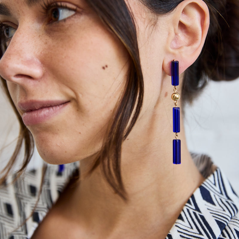 One of Peg's Hardware's Capri earrings, hanging from a model's ear.