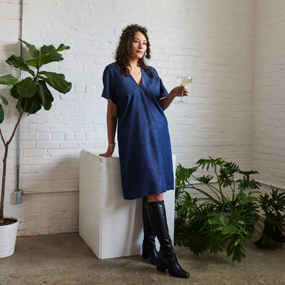 the denim version of ARW's deep V block dress, being worn on a model.