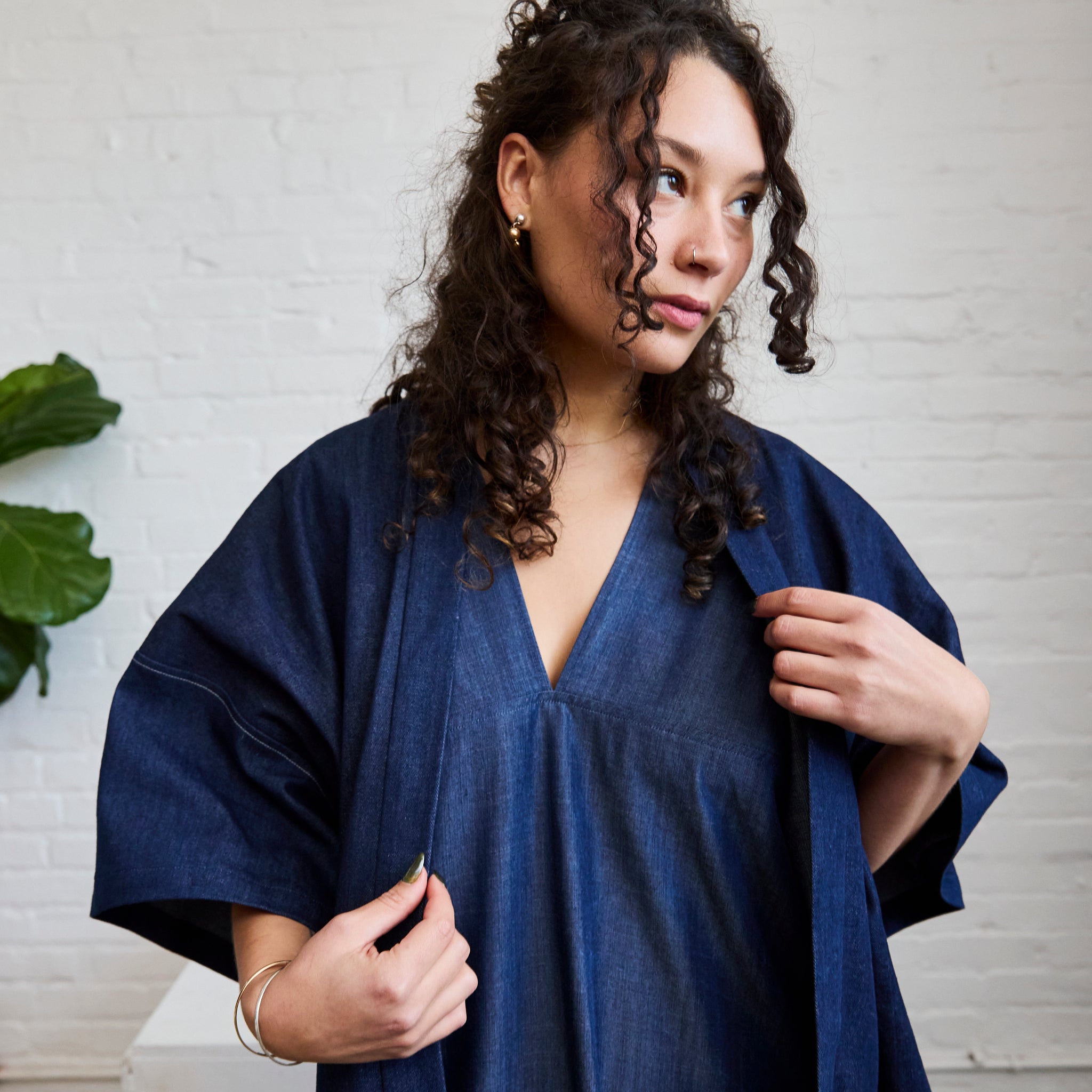 the denim version of ARW's open layering jacket, being worn on a model.