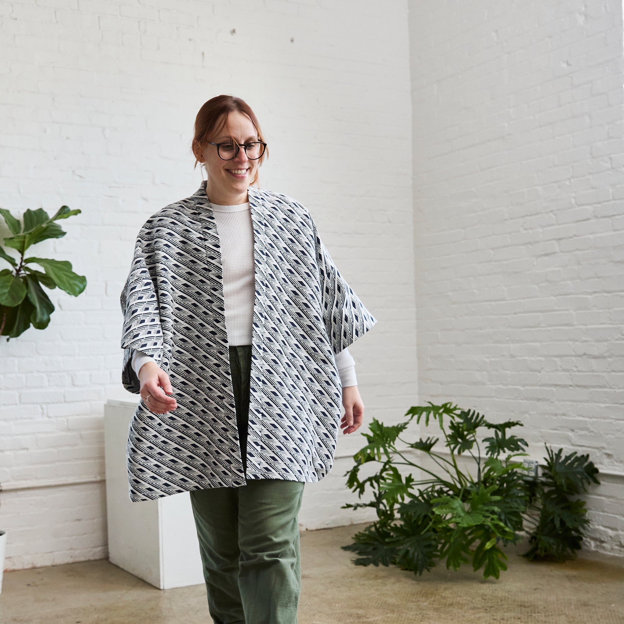 the navy and white version of ARW's open layering jacket, being worn on a model.