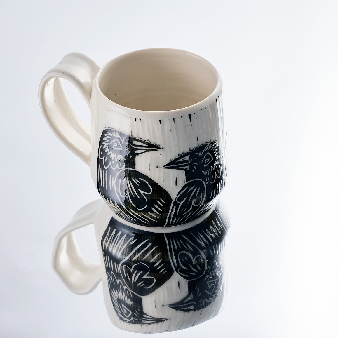 White ceramic mug with a raven design