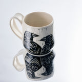 White ceramic mug with a raven design