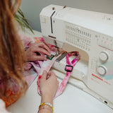 Katie Addo sewing Goldy Way label onto apron