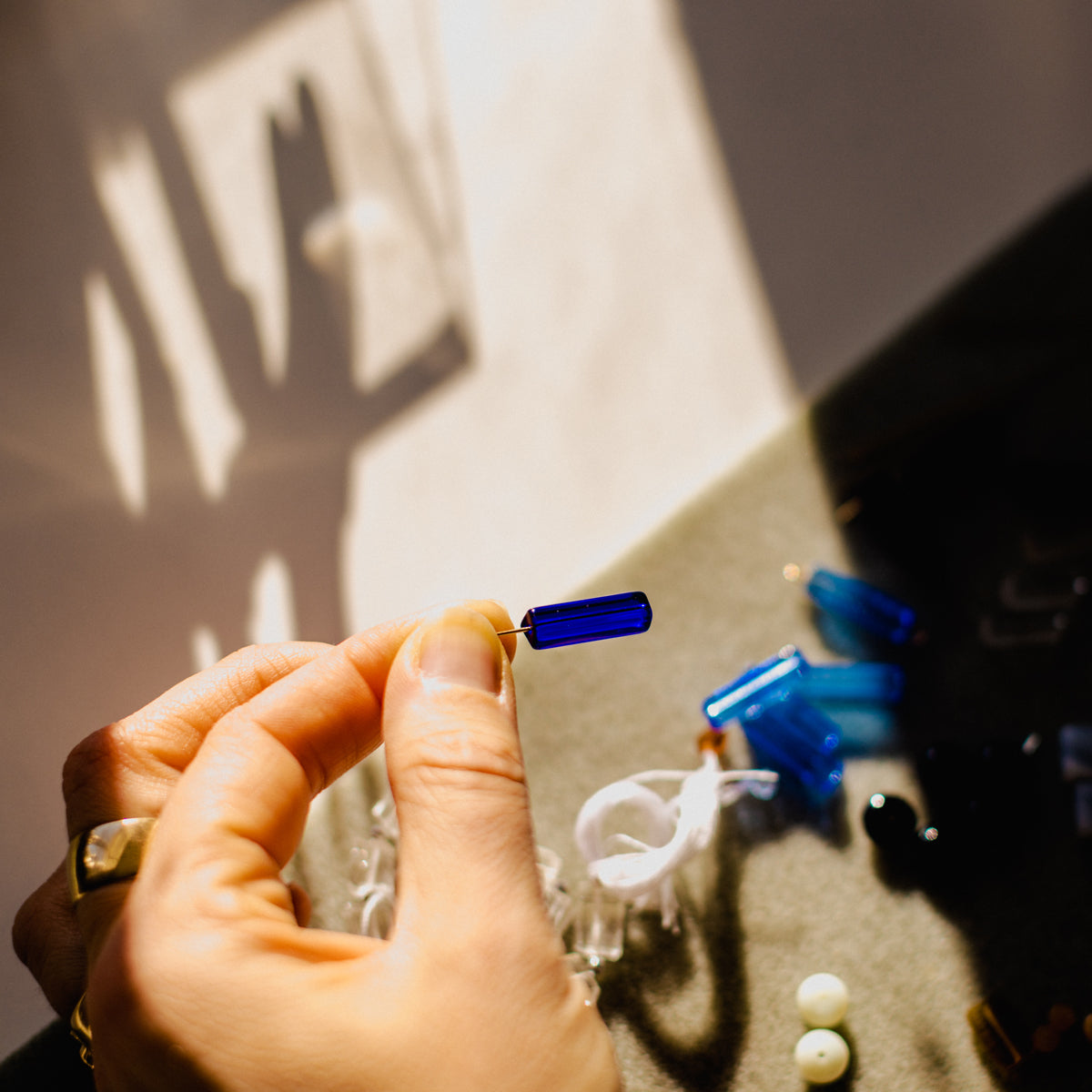 hand holding a blue bead from a Peg's Harware Earring