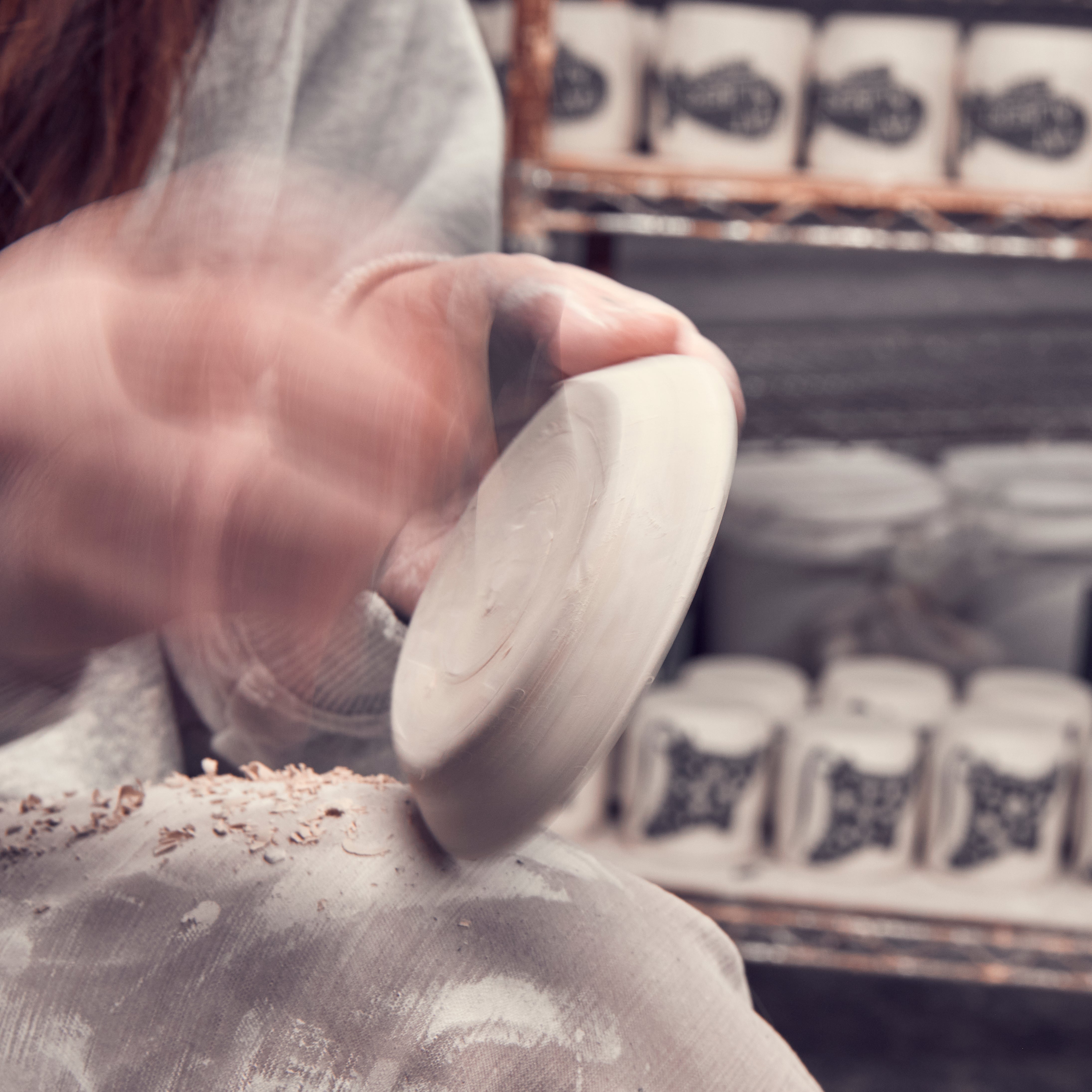 Buffalo NY artist hand finishing ceramic dish in her studio